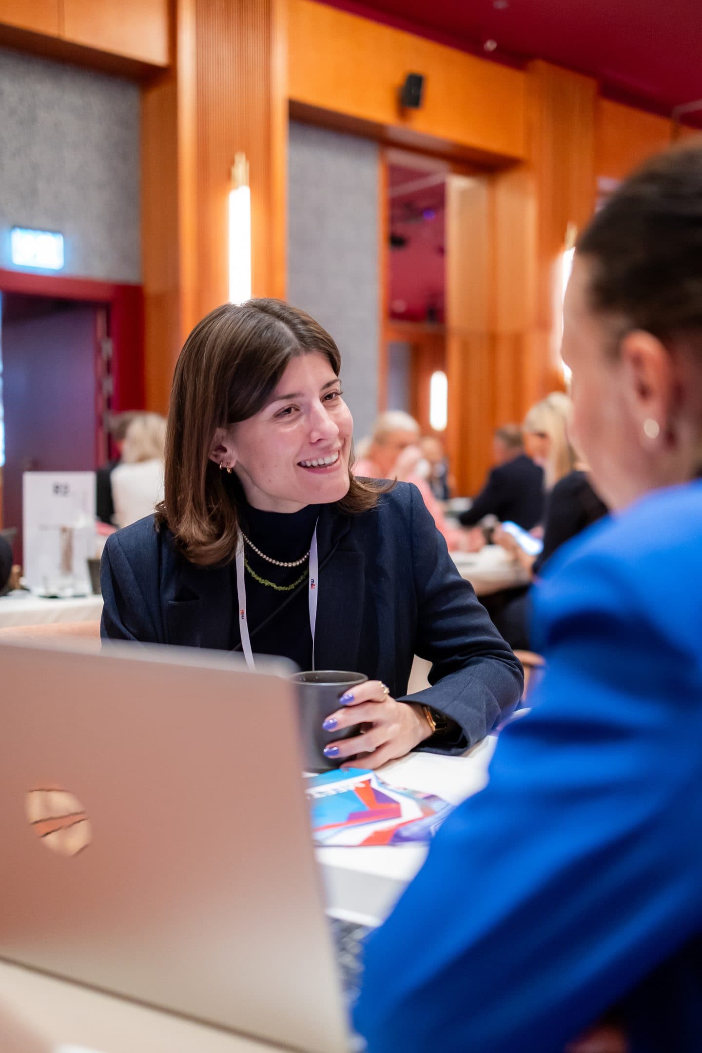 A buyer laughing with a supplier across the table during a one-to-one meeting