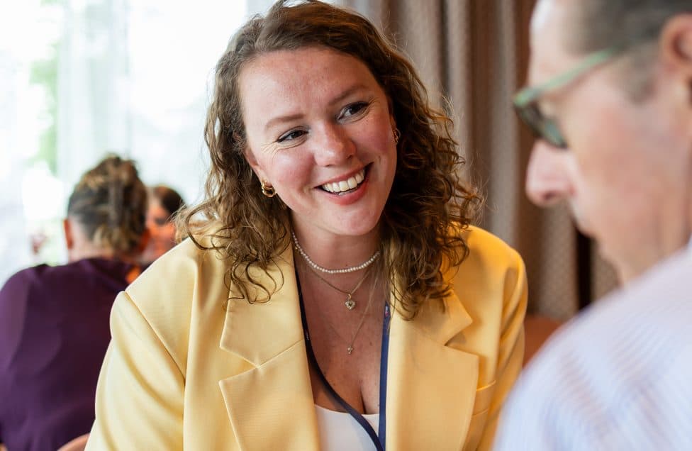 A buyer smiling across the table during a one-to-one meeting