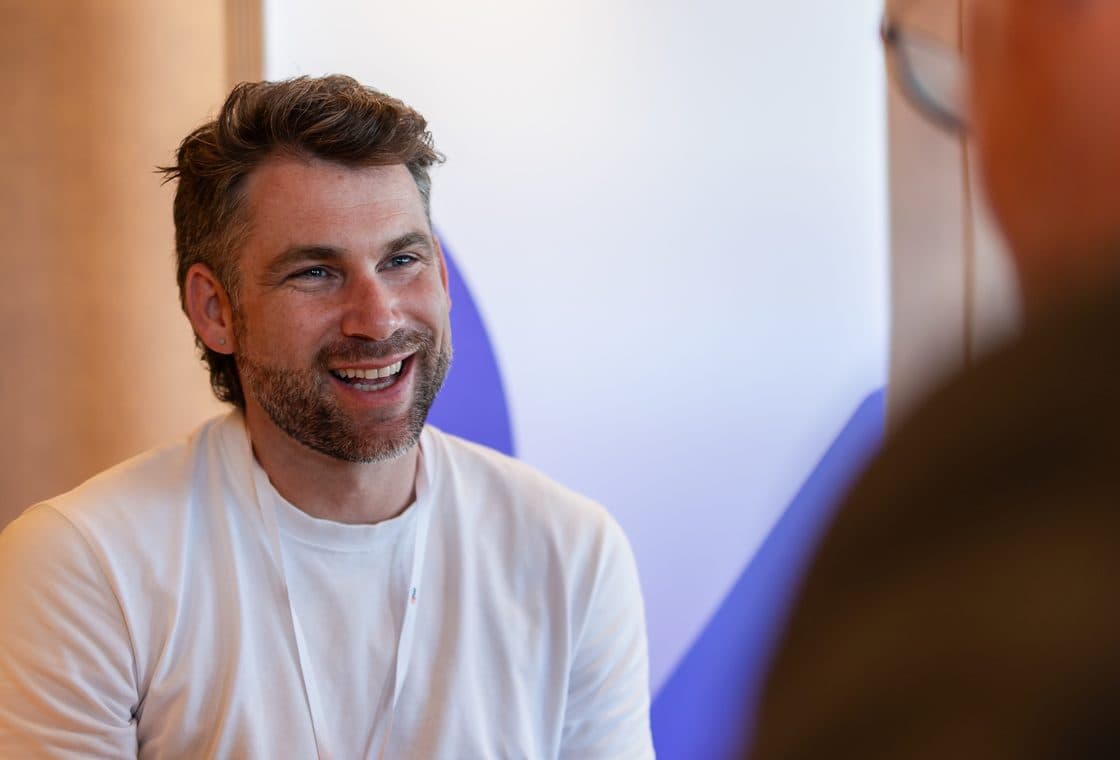 A buyer smiling mid-conversation during a one-to-one meeting at an M&I event